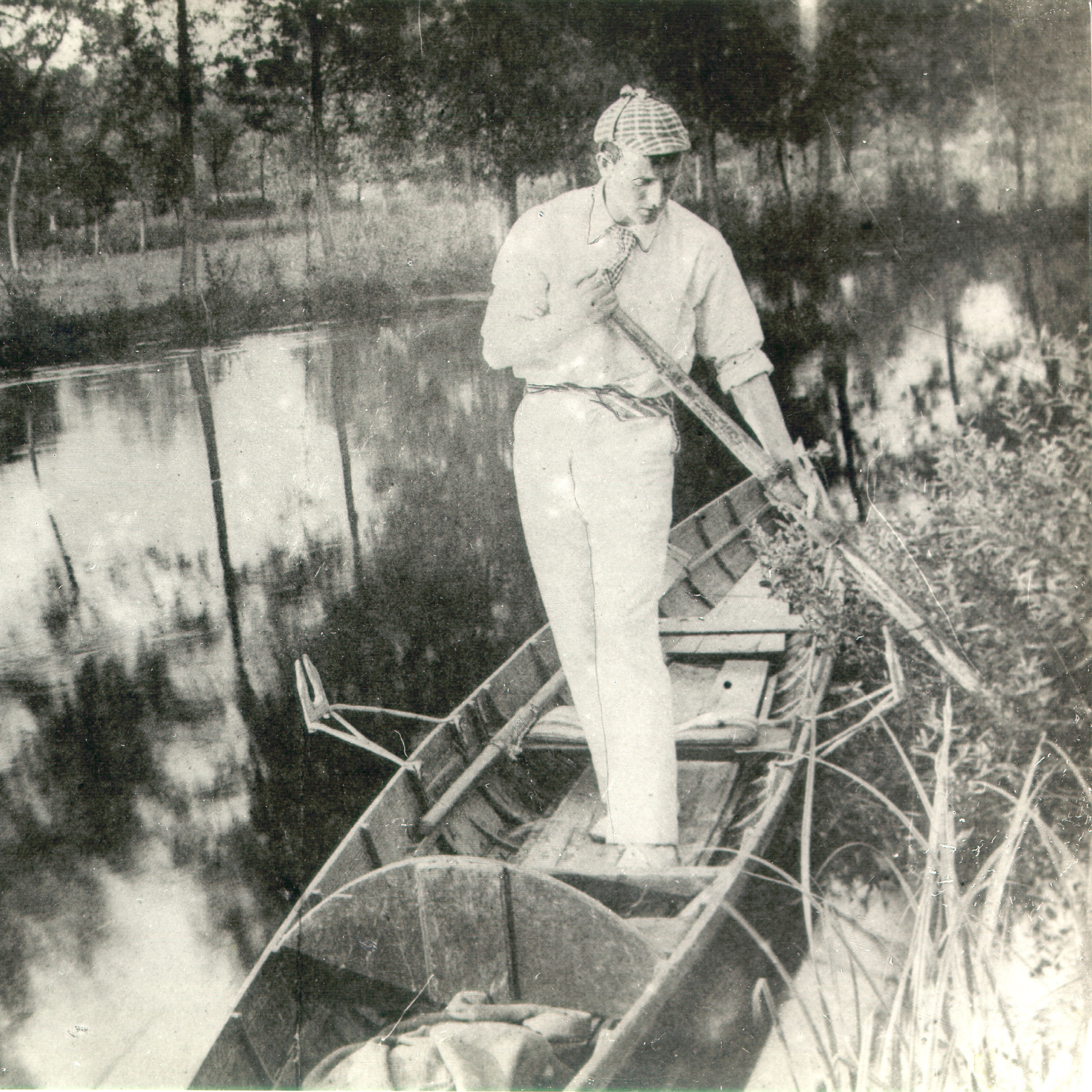 Sidney Paget in a deerstalker hat standing in a rowing boat pushing away from the shore with an oar